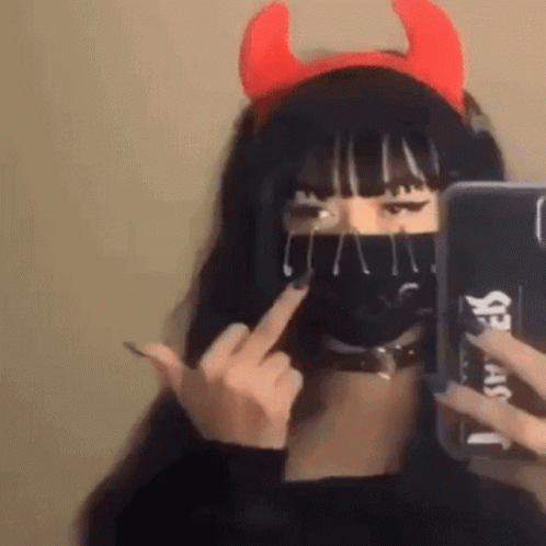 a female with horns and nose ring holding a smart phone