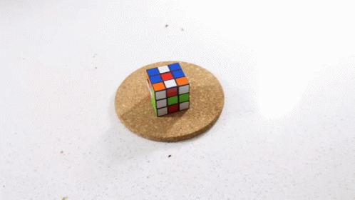 a rubik cube sitting on top of a blue disk