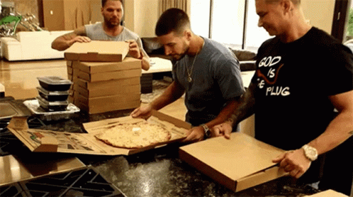 the men are moving pizza into boxes