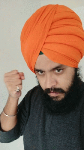a man in a turban holds a cell phone