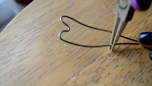 a heart shaped wire sitting on top of a wooden table