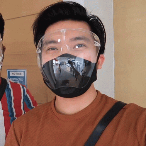 a guy is wearing a face mask and another man has blue paint on his head