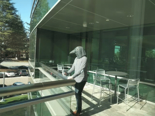 man in front of glass office building outside