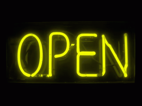 a neon open sign is lit up with green lights