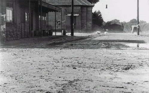 a black and white po of the street with water flooding