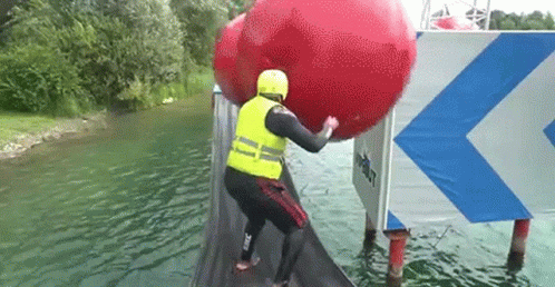the person in blue life vest is standing on a buoy