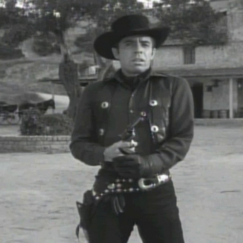 a black and white po of a man wearing a cowboy outfit