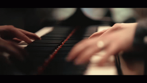 hands typing on a piano keyboard using blue gloves