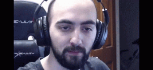a bearded man wearing headphones with no hair
