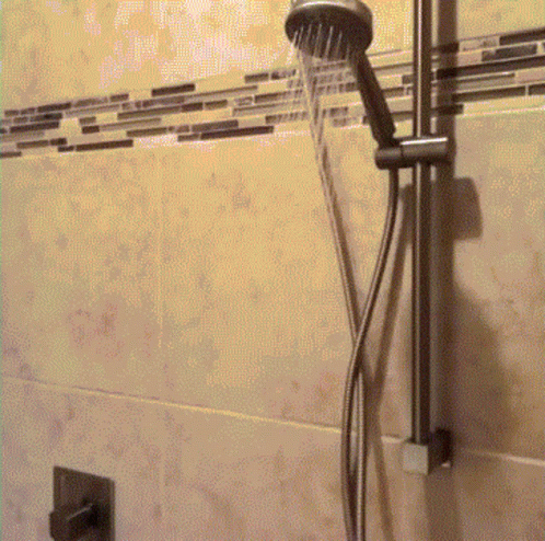 this is a shower in a bathroom with blue tiles