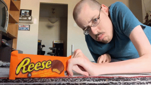 a man is laying down by a piece of candy