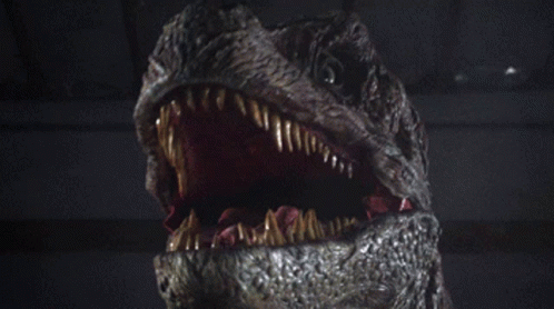 a large dinosaur head is shown in a dark room