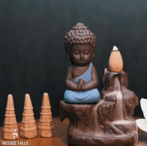 the small buddha statue is sitting beside several smaller ceramic ornaments