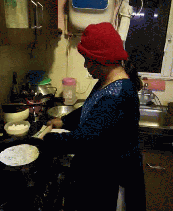 there is a woman that is cooking in the kitchen