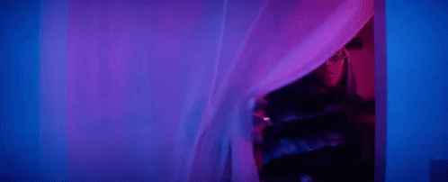a room with a curtain that has pink lights in it