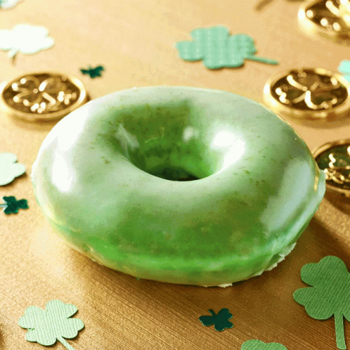 a green doughnut with white frosting sitting on a table