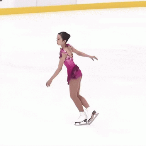 the female figure is standing on a skating rink