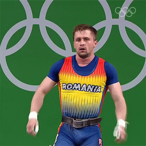 a man wearing an artistic t - shirt in front of a olympic ring