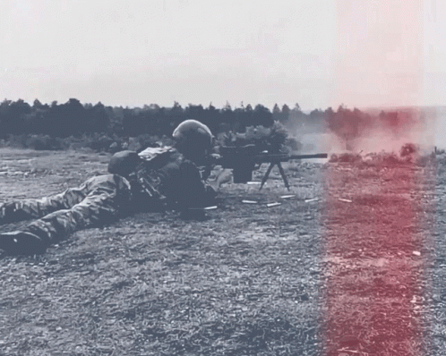a soldier laying on the ground while wearing gas mask