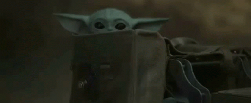 yoda with a backpack standing up behind a desk