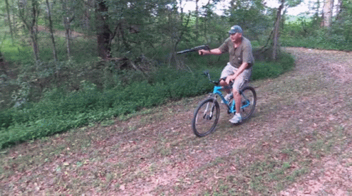 a man rides his bicycle in the woods