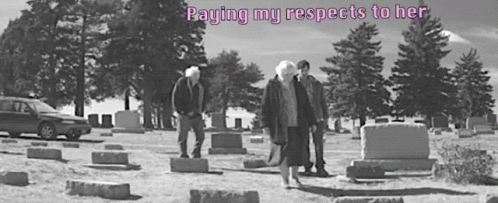 three men standing near tombstones in a cemetery