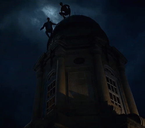 three people on top of a tower at night