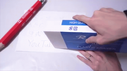 a person wearing blue rubber gloves putting an eraser on a card