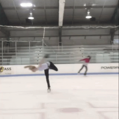 two skateboarders are performing on the ice