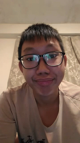 a young man wearing glasses stares into the camera