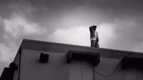 a man stands on the roof of his apartment