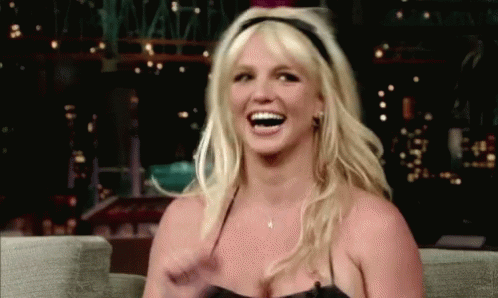 a woman laughing while wearing a leather skirt on the late show