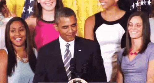 obama is standing next to some of the women's choirs