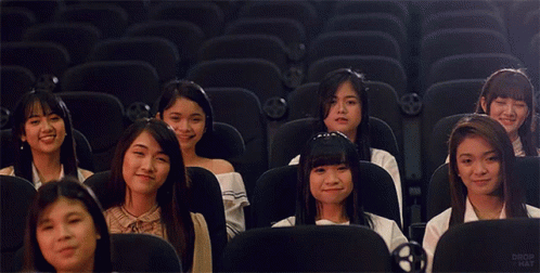 a group of young women in front of a row of empty chairs