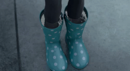 a pair of legs with polka dot green welly boots