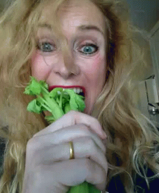 a woman holding broccoli with a purple nose