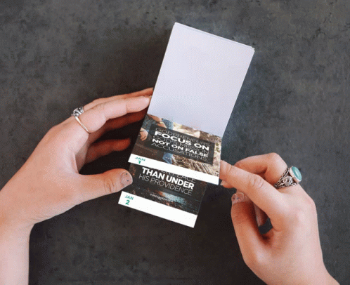 two hands holding some kind of business card
