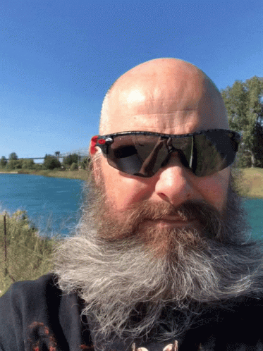 an odd looking man wearing sunglasses and a beard