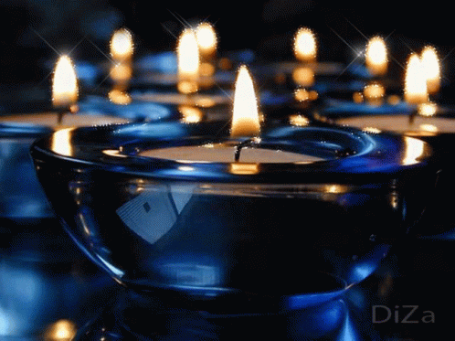 a row of lit candles set against a black background