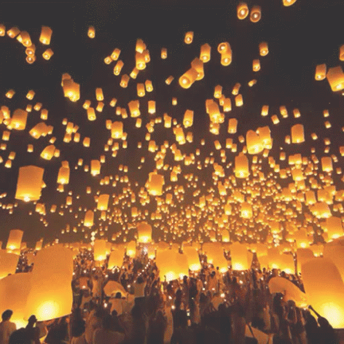 large group of people surrounding floating lanterns with people in it