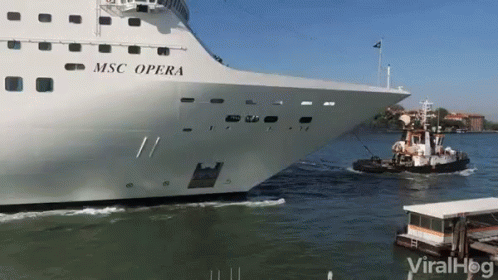 a cruise ship passing another boat in the water