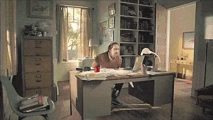 a man is at a desk with his computer