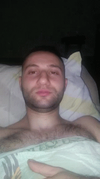 a man in bed with soing on his hand