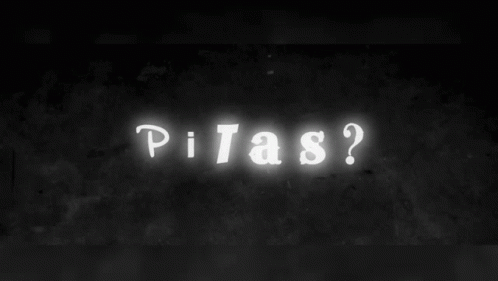 a neon sign reads pixas? on the side of a building