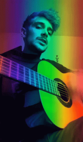 the man is playing the guitar with his colorful light