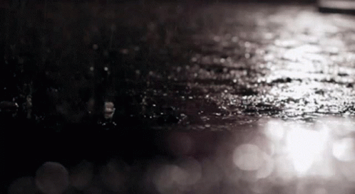 water droplets on an umbrella on a dark street