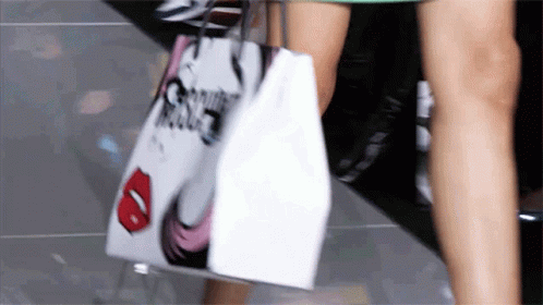 a person with blue legs holds shopping bags