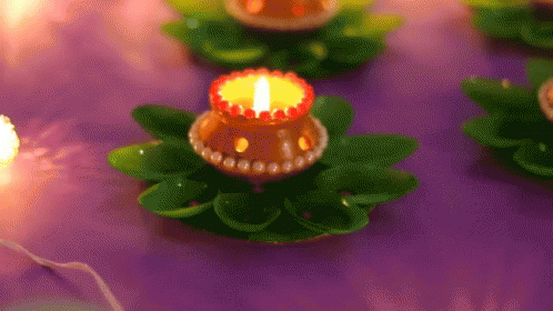 blue lighted candles on small flowers on a purple cloth