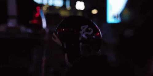 a person wearing a helmet standing in the dark