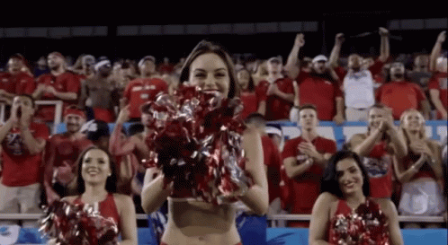 a cheerleader wearing a bikini and holding her pom poms